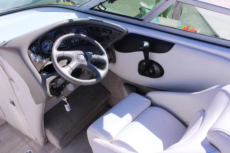 Slide: The Image of 2005 Crownline 266 BR boat cockpit with steering wheel and control panel. - 2