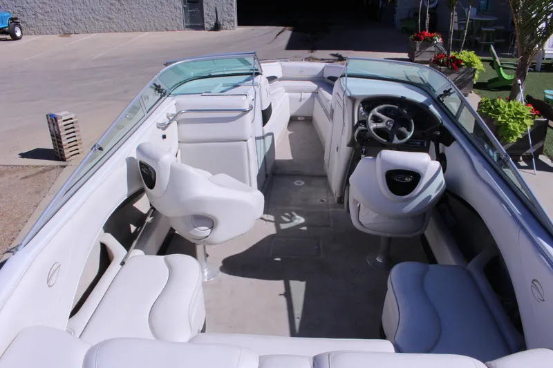 Slide: The Image of 2005 Crownline 266 BR boat interior with white seating and steering wheel. - 4