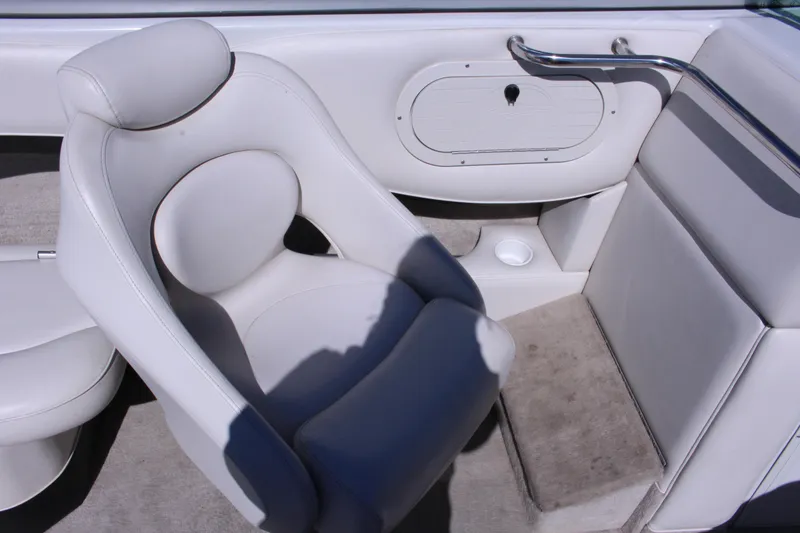 Slide: The Image of 2005 Crownline 266 BR boat interior with white seating and storage compartment. - 5