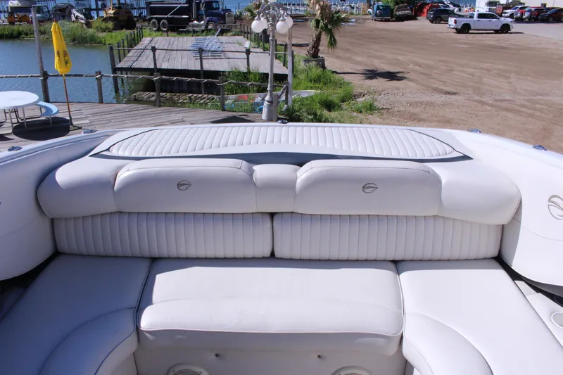 Slide: The Image of 2005 Crownline 266 BR boat with white leather seating, dockside view. - 8