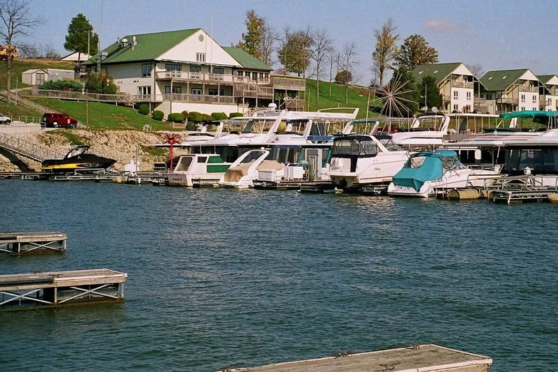 Slide: The Image of Boats docked at a marina with waterfront buildings, featuring a 2018 Misty Harbor S2385SU. - 12