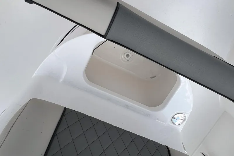 Slide: The Image of 2026 Key West 210 Bay Reef boat interior with cushioned seating and storage compartments. - 13