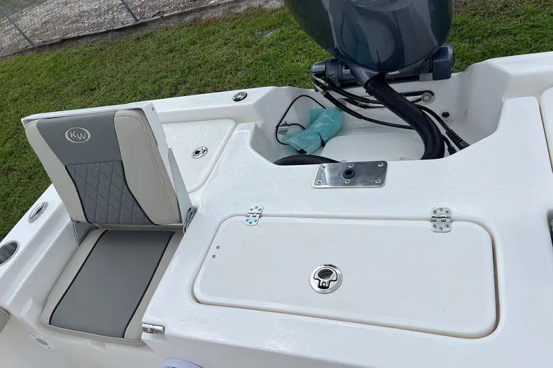 Slide: The Image of 2026 Key West 210 Bay Reef boat interior with cushioned seating and storage compartments. - 17