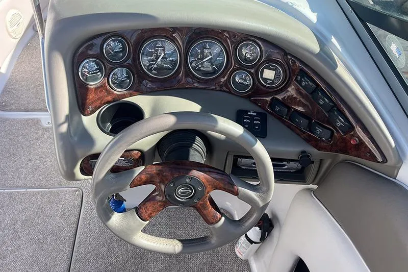 Slide: The Image of Dashboard of a 2005 Crownline 266 BR boat with wood accents and gauges. - 2