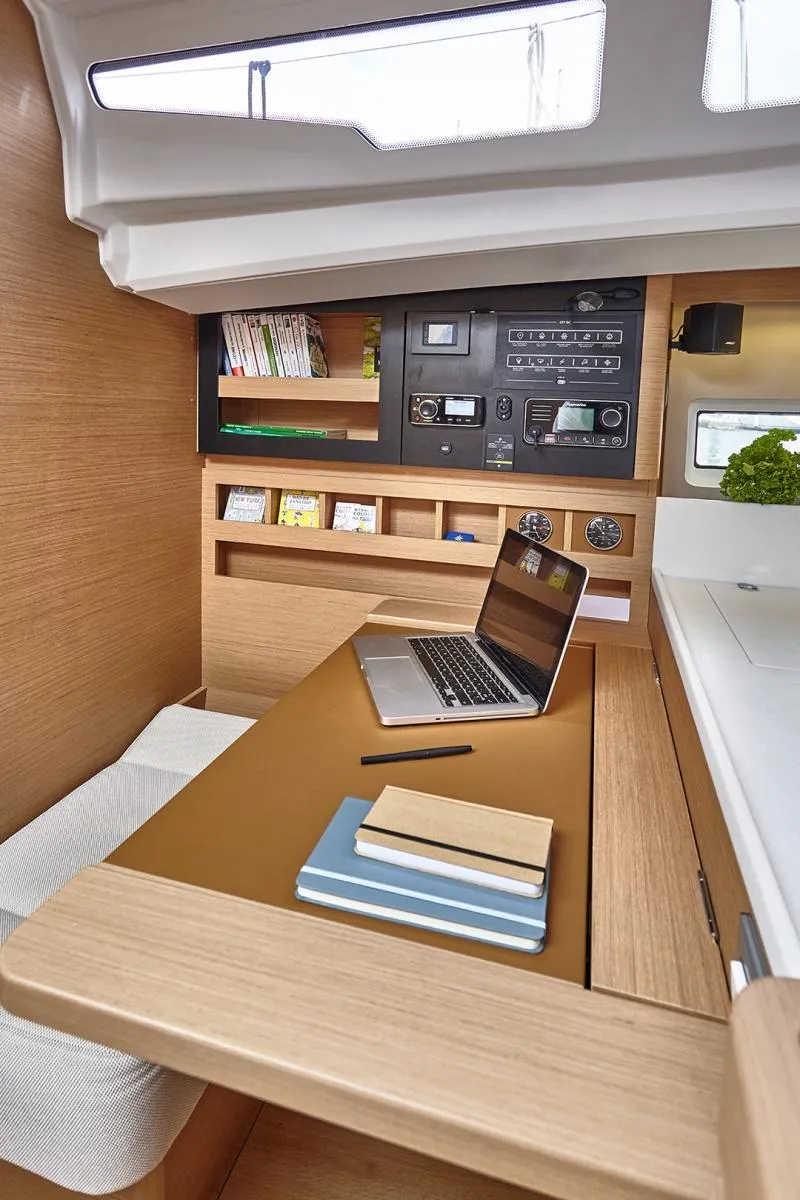 Slide: The Image of 2023 Jeanneau Sun Odyssey 440 interior with desk, laptop, and shelves. Modern yacht workspace. - 15