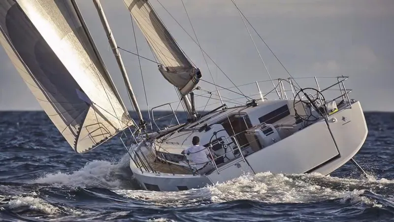 Slide: The Image of 2023 Jeanneau Sun Odyssey 440 sailing on open sea with full sails. - 2