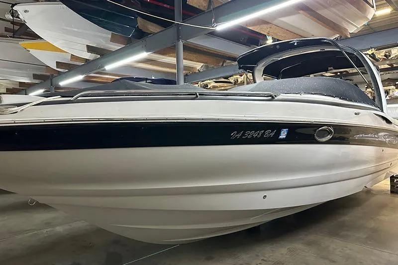The Image of 2005 Crownline 316 boat in indoor storage, showcasing sleek design and white hull. - 1