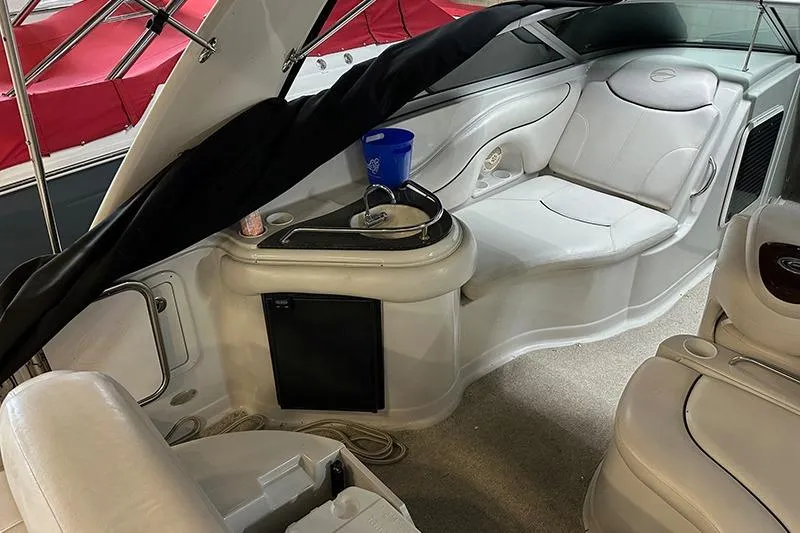 Slide: The Image of Interior of a 2005 Crownline 316 boat with white seating and a small sink area. - 7