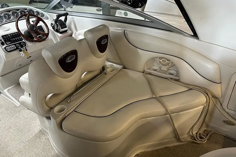 Slide: The Image of 2005 Crownline 316 boat interior with beige seating and dashboard controls. - 8
