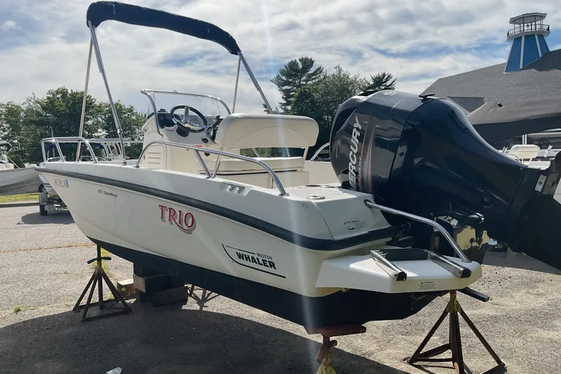 Slide: The Image of 2014 Boston Whaler 170 Dauntless boat with Mercury engine on display outdoors. - 4