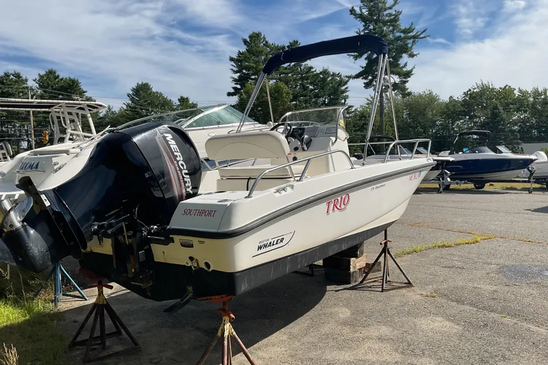 Slide: The Image of 2014 Boston Whaler 170 Dauntless boat with Mercury engine on stands outdoors. - 6
