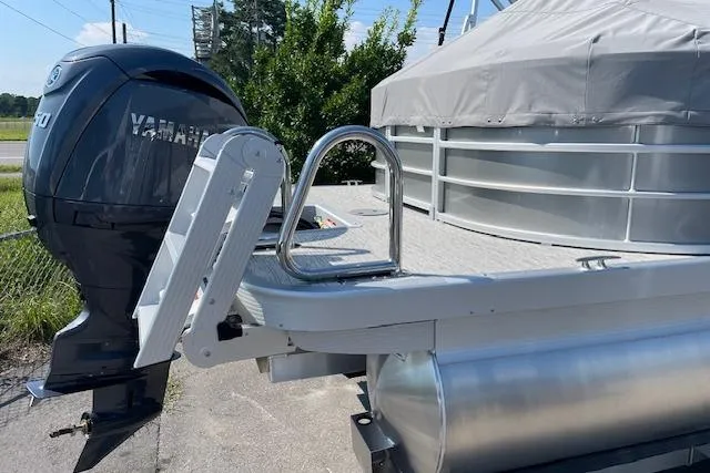 Slide: The Image of 2025 Bennington L22 pontoon boat with Yamaha outboard motor, docked and covered. - 2