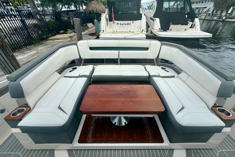 Slide: The Image of 2019 Tiara Sport 38 LS boat interior with luxurious seating and wooden table. - 15