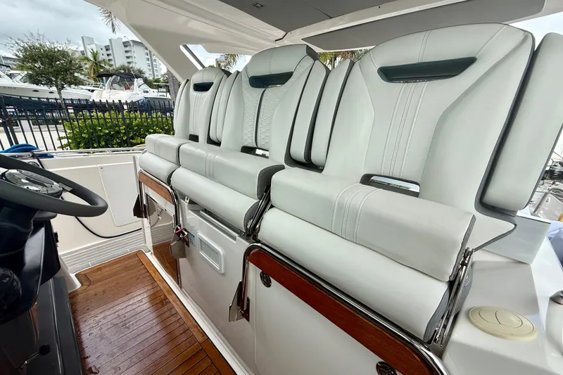Slide: The Image of 2019 Tiara Sport 38 LS boat interior with luxurious white seating and wooden flooring. - 18