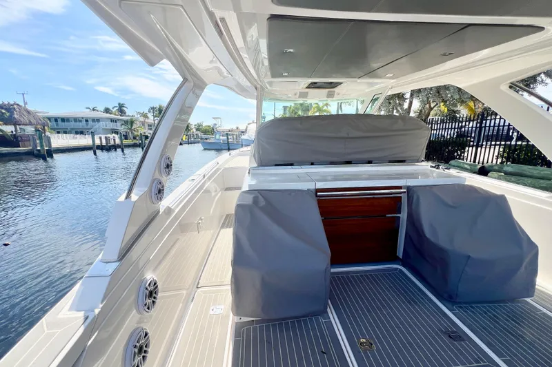 Slide: The Image of 2019 Tiara Sport 38 LS boat interior with covered seating and waterfront view. - 22