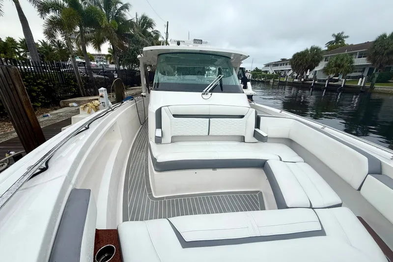 Slide: The Image of 2019 Tiara Sport 38 LS boat with sleek seating and modern design by the water. - 25