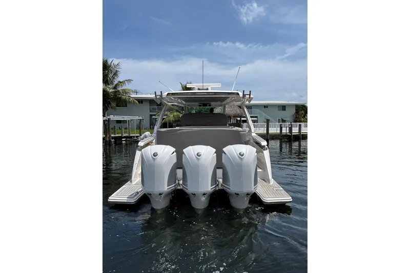 Slide: The Image of 2019 Tiara Sport 38 LS boat with triple outboard engines docked in a marina. - 3