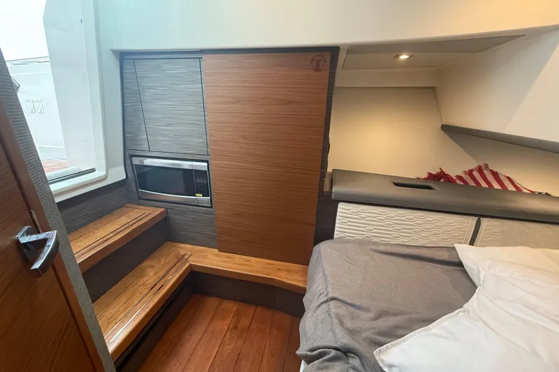 Slide: The Image of Interior of 2019 Tiara Sport 38 LS yacht with bed, microwave, and wooden steps. - 30