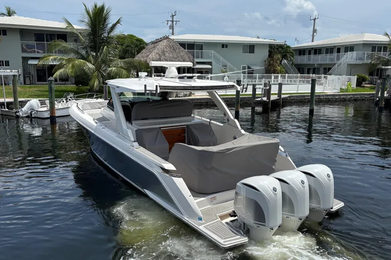 Slide: The Image of 2019 Tiara Sport 38 LS boat with triple outboard engines docked in a marina. - 34