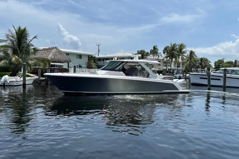 Slide: The Image of 2019 Tiara Sport 38 LS boat docked in a sunny marina setting. - 6