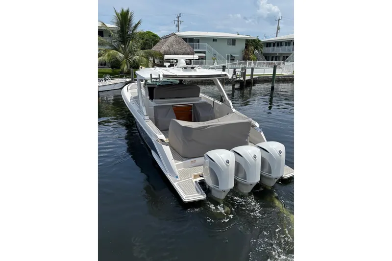 Slide: The Image of 2019 Tiara Sport 38 LS boat with triple outboard engines docked in marina. - 7
