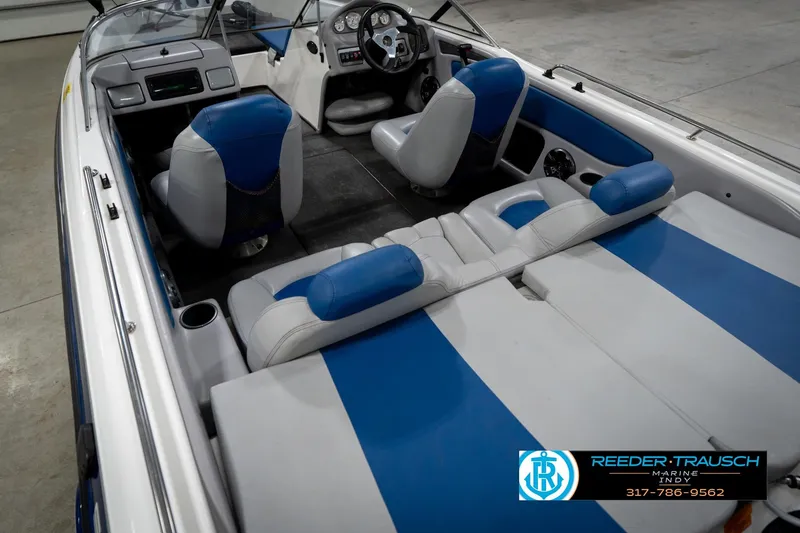 Slide: The Image of 2006 Skeeter SL 190 boat interior with blue and white seating, steering console, and cup holders. - 13