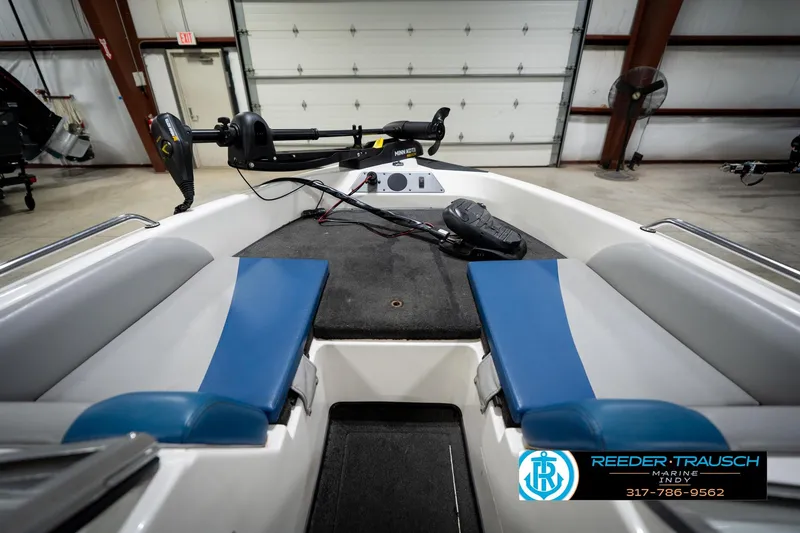 Slide: The Image of 2006 Skeeter SL 190 boat interior with blue seats and trolling motor in garage. - 16