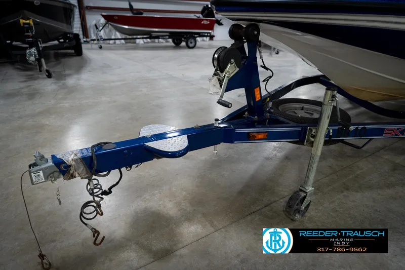 Slide: The Image of 2006 Skeeter SL 190 boat trailer in a showroom, featuring a blue frame and winch. - 48