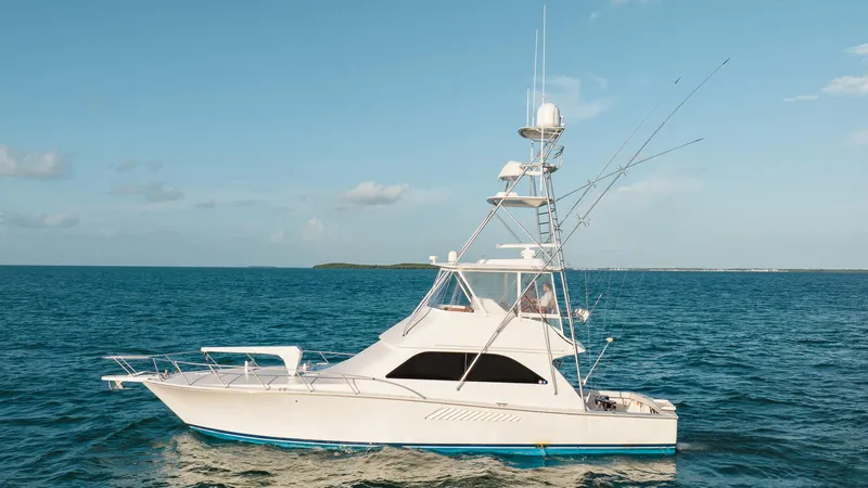 Slide: The Image of 2005 Viking 48 Convertible yacht cruising on open sea under clear blue sky. - 2