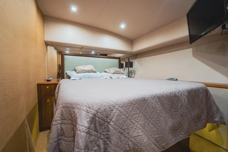 Slide: The Image of Luxurious bedroom interior of 2005 Viking 48 Convertible yacht with cozy bedding and ambient lighting. - 21