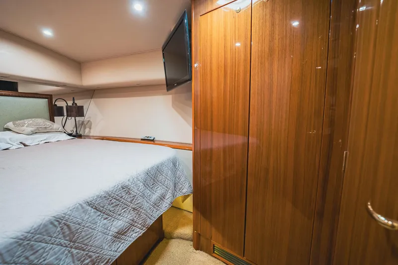 Slide: The Image of Luxurious cabin interior of 2005 Viking 48 Convertible yacht with wood paneling and cozy bed. - 25