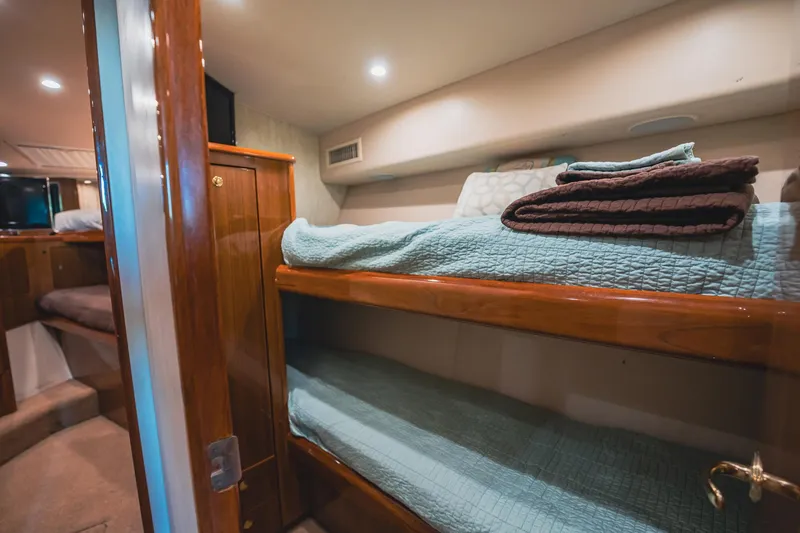 Slide: The Image of 2005 Viking 48 Convertible yacht interior with cozy bunk beds and wooden finishes. - 28