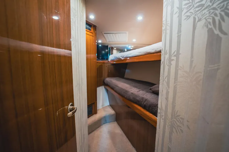Slide: The Image of 2005 Viking 48 Convertible yacht interior with cozy bunk beds and wooden finish. - 29