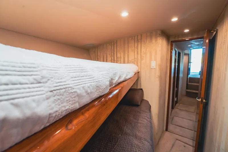 Slide: The Image of Interior of 2005 Viking 48 Convertible yacht with cozy bunk beds and warm lighting. - 32