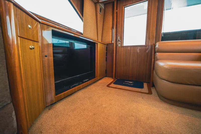 Slide: The Image of Interior of 2005 Viking 48 Convertible yacht with wood paneling and plush seating. - 4
