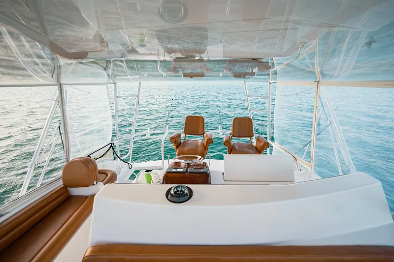 Slide: The Image of 2005 Viking 48 Convertible yacht interior with ocean view, featuring leather seating and helm controls. - 41