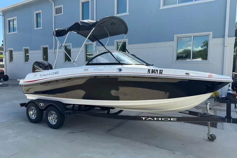 Slide: The Image of 2021 Tahoe 550 TS boat on trailer, parked outside a building. - 4