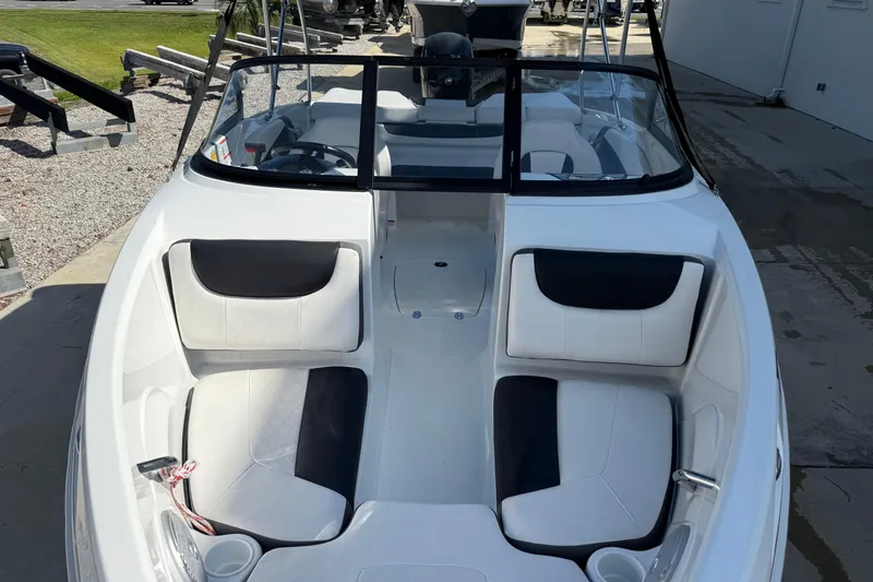 Slide: The Image of 2021 Tahoe 550 TS boat interior with white and black seating, docked outdoors. - 7