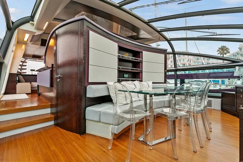 Slide: The Image of Luxurious 2011 Baia yacht interior with modern dining area, glass table, and transparent chairs. - 28
