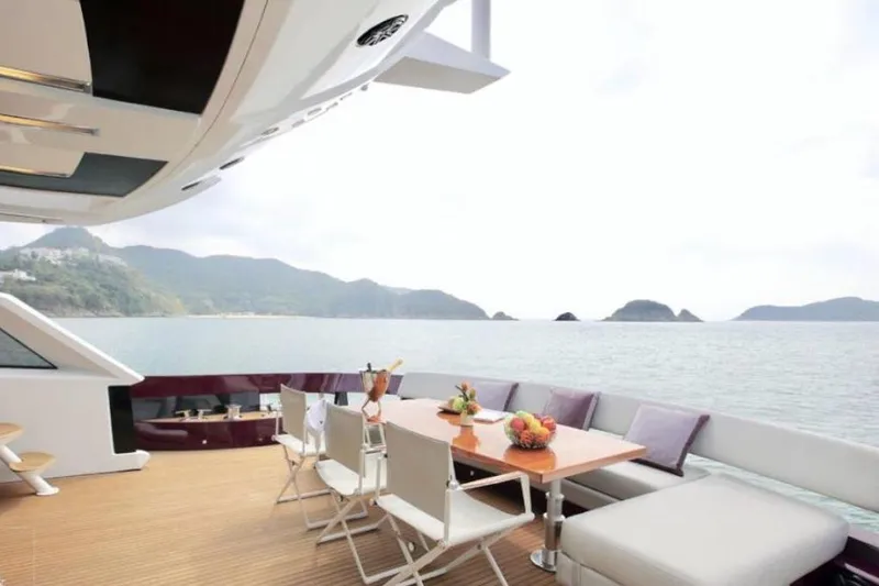 Slide: The Image of Luxurious Baia ONE HUNDRED yacht deck with dining area, ocean view, and scenic mountains, 2011 model. - 32