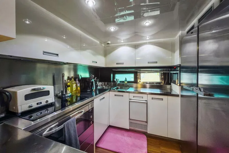 Slide: The Image of Modern yacht kitchen with stainless steel appliances, white cabinets, and pink rug, Baia xxx 2011. - 64