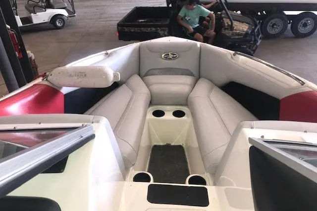 Slide: The Image of 2004 Centrian C4 boat interior with white seating and cup holders in a garage setting. - 3