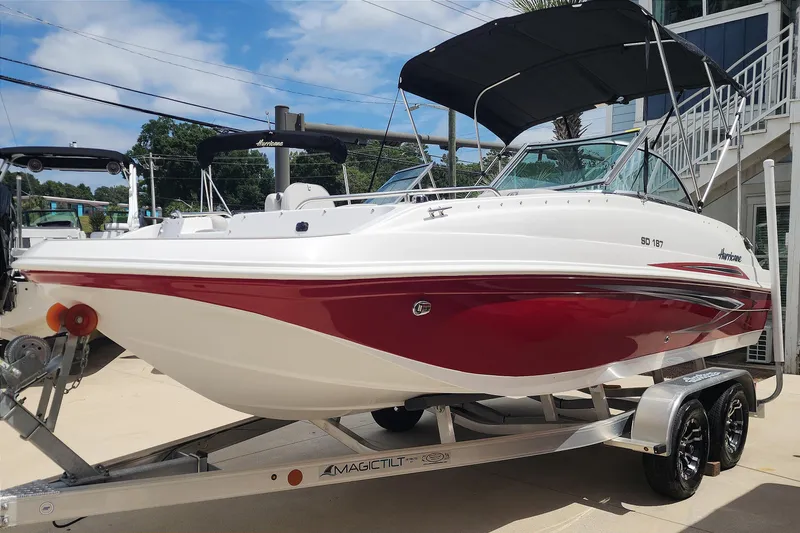 Slide: The Image of 2023 Hurricane SunDeck 187 OB boat on trailer, featuring red and white design. - 4