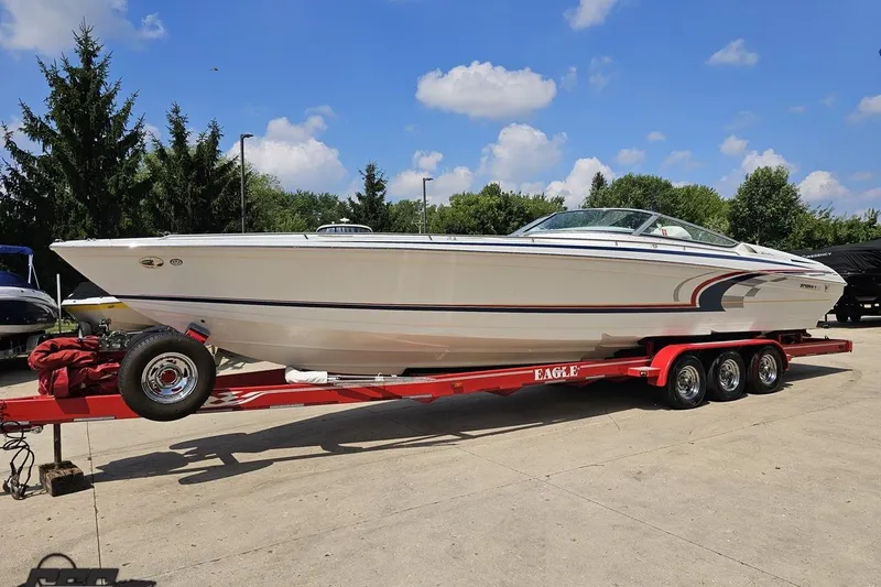 Slide: The Image of 2005 Formula 353 FASTech boat on red trailer, parked outdoors under blue sky. - 17