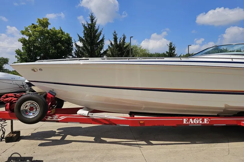 Slide: The Image of 2005 Formula 353 FASTech boat on red Eagle trailer, parked outdoors under blue sky. - 18