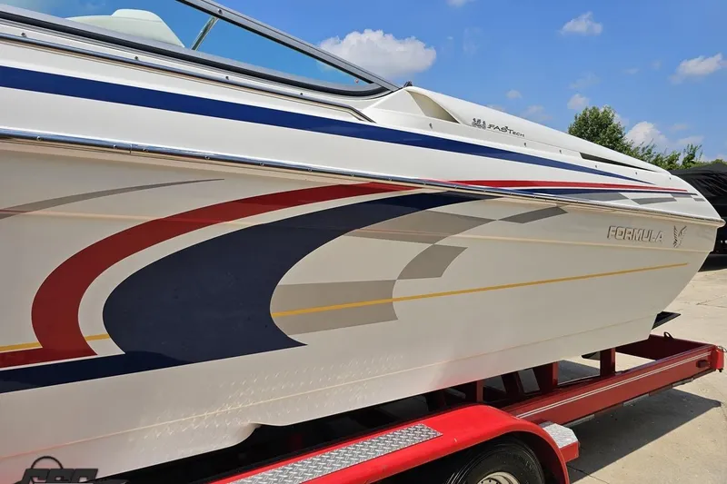 Slide: The Image of 2005 Formula 353 FASTech boat with colorful graphics on a red trailer. - 20