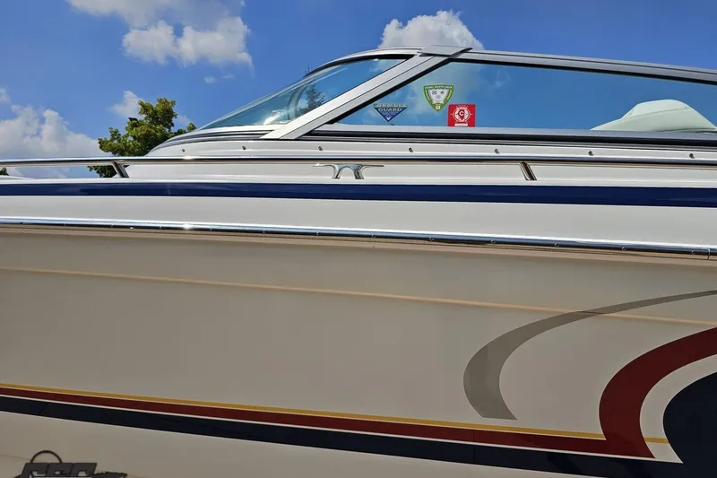 Slide: The Image of 2005 Formula 353 FASTech boat with sleek design and vibrant decals under a clear sky. - 21