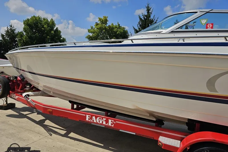 Slide: The Image of 2005 Formula 353 FASTech boat on red Eagle trailer, parked outdoors under blue sky. - 22