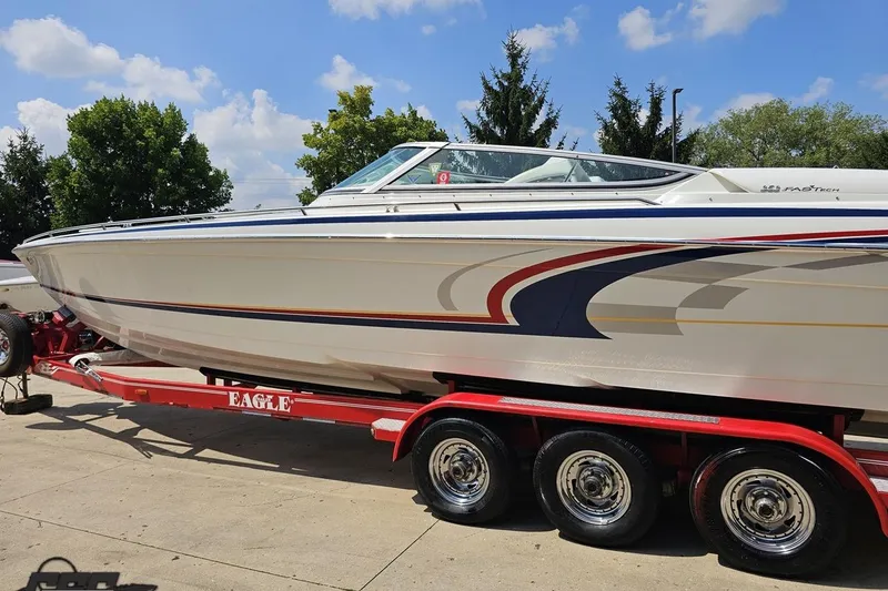 Slide: The Image of 2005 Formula 353 FASTech boat on red trailer under blue sky. - 24
