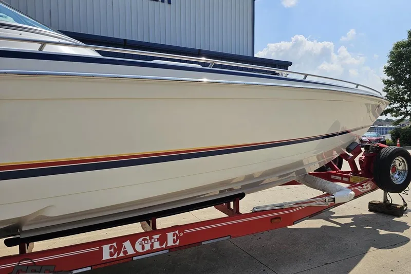 Slide: The Image of 2005 Formula 353 FASTech boat on red Eagle trailer, parked outdoors. - 4